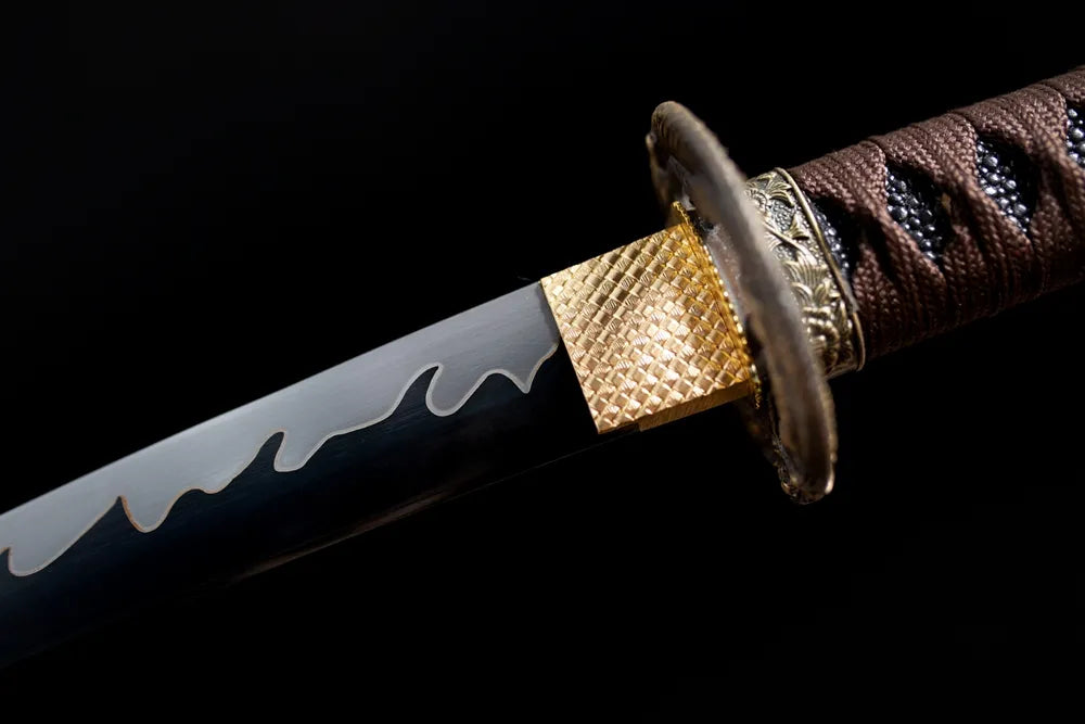 Upper T10 clay‑tempered wakizashi blade brass habaki wavy wave‑hamon temper‑line macro close‑up