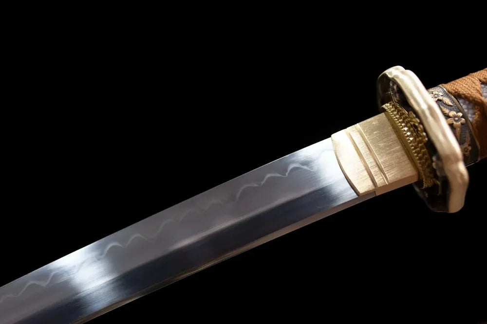 Upper T10 clay‑tempered steel blade brass habaki visible wave hamon temper‑line macro close‑up
