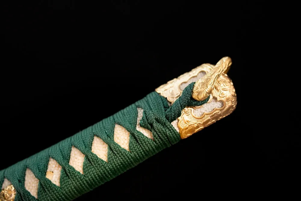 Top clan‑floral‑crest‑sculpted gilded‑alloy kashira pommel front close‑up