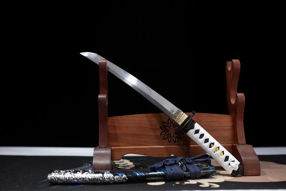 Slanted upright drawn short Ghost‑Of‑Tsushima‑theme wakizashi wooden shelf front perspective