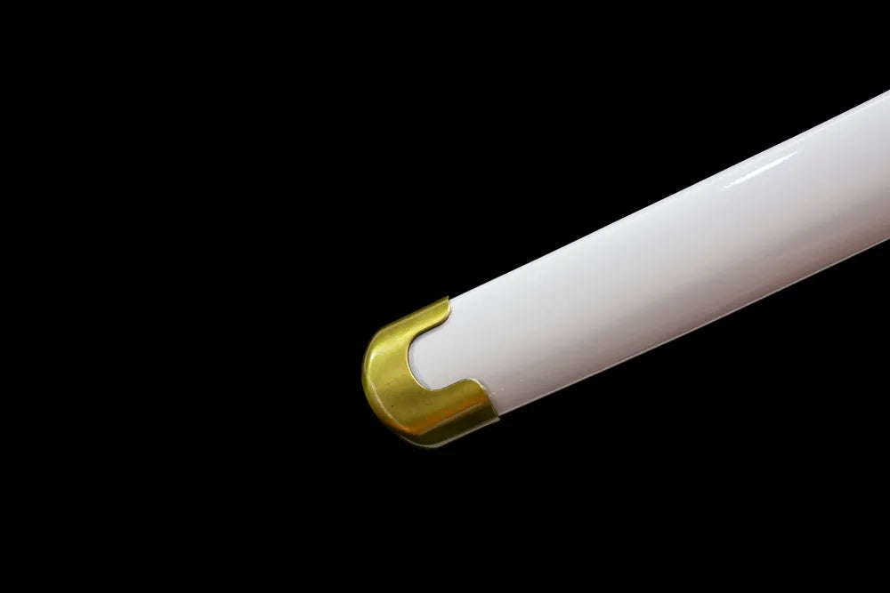 Bottom smooth off‑white scabbard brass metal end cap close‑up