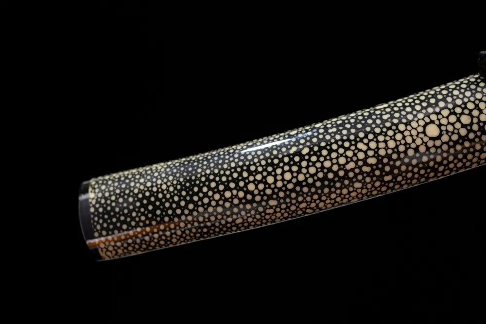 Bottom ink‑black saya matte‑silver alloy kojiri end‑cap close‑up