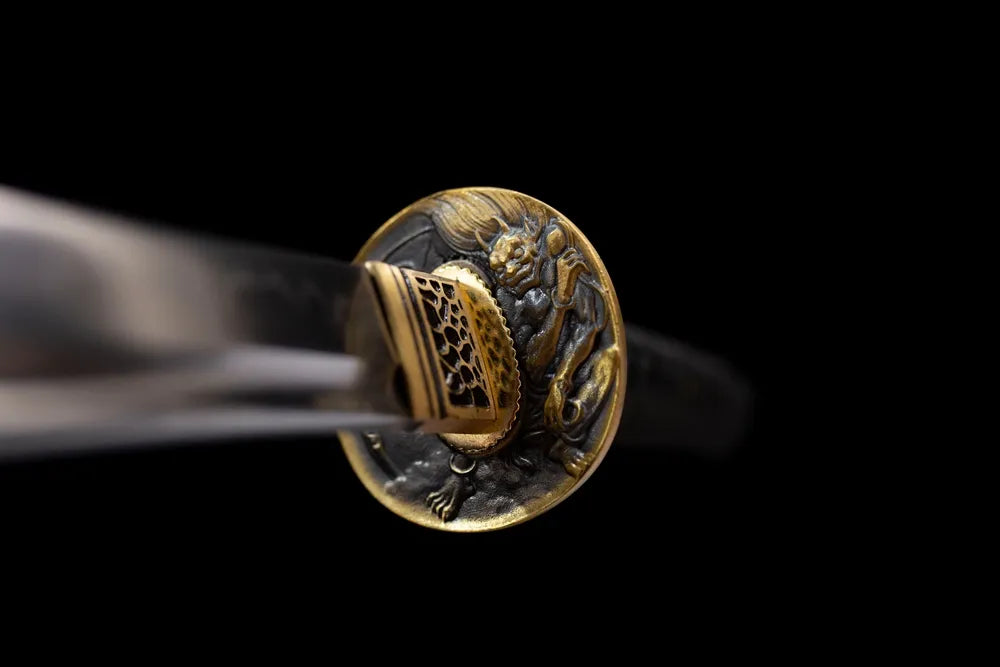 Front weathered round brass demon‑mask‑theme wakizashi hand‑guard close‑up