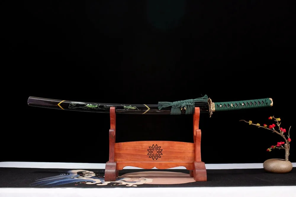 Horizontal laid closed moss‑green hand‑painted grass‑leaf‑grasshopper Vibrant‑Grasshopper‑Katana scabbard flat table‑top front display