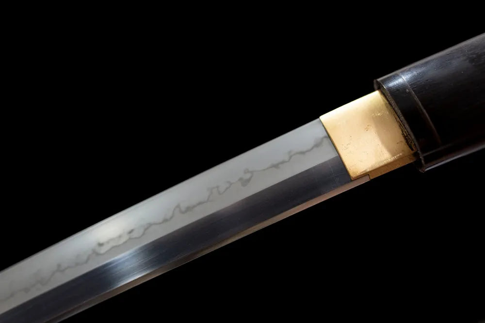 Upper T10 clay‑tempered steel blade brass habaki natural hamon temper‑line macro close‑up