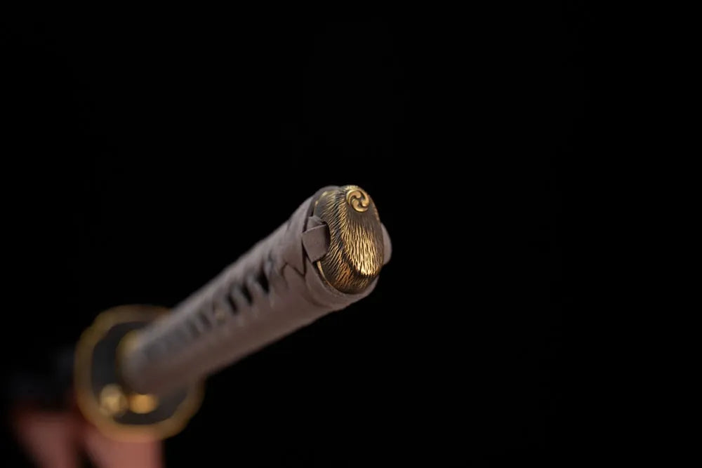 3D‑sculpted vortex‑kamon‑emblem brass pommel‑cap detail shot