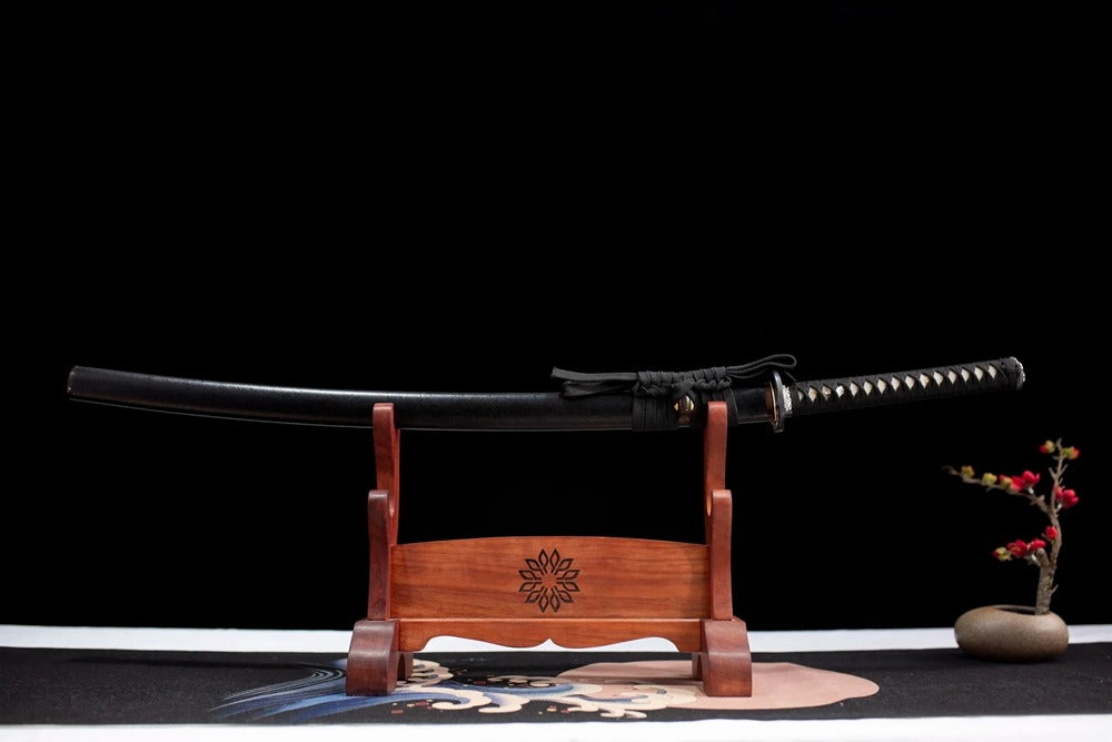 Horizontal laid closed matte‑black Lion‑Chop scabbard flat table‑top front display