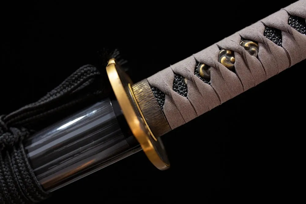 Vortex‑kamon‑relief brass fuchi grip‑ring macro close‑up