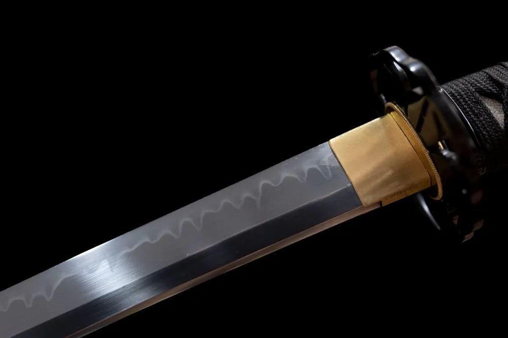 Upper T10 clay‑tempered katana blade brass habaki irregular gunome hamon temper‑line macro close‑up