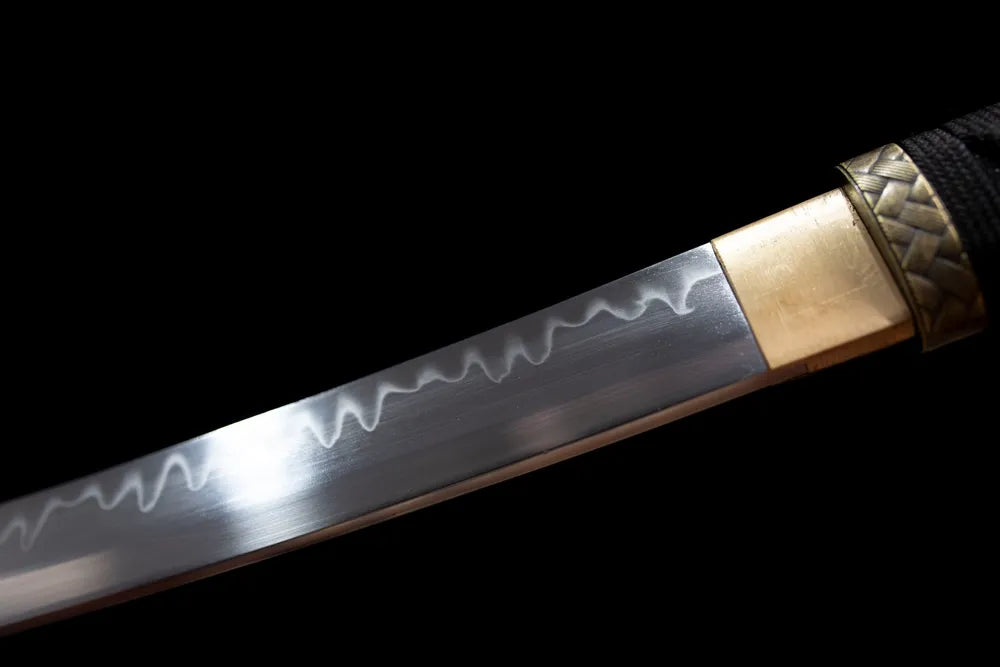Upper T10 clay‑tempered katana blade brass habaki sanbonsugi three‑peak hamon temper‑line macro close‑up