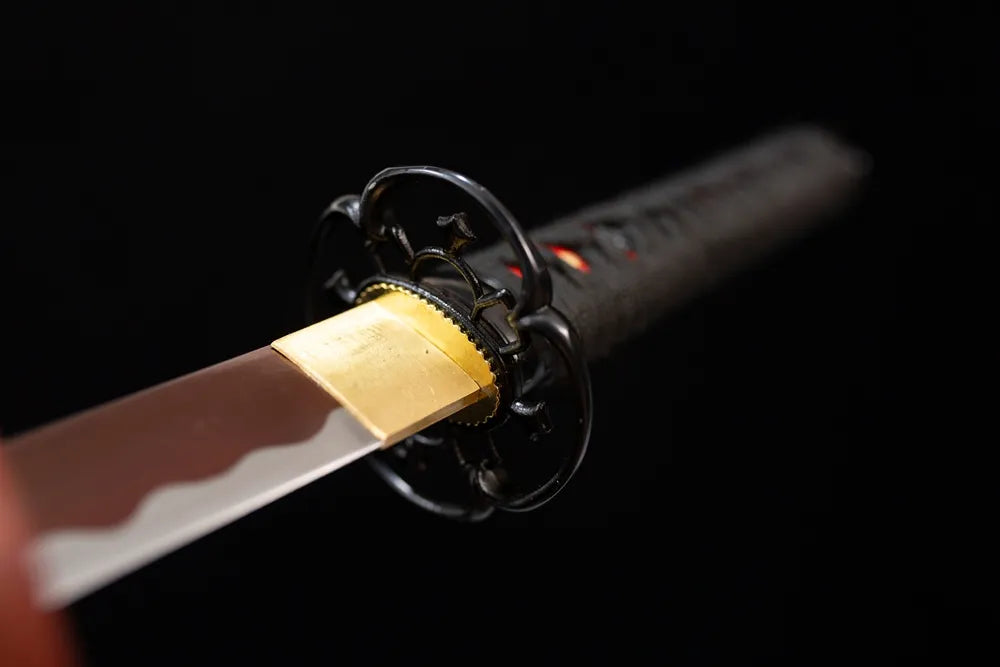 Front open‑work floral‑relief black‑iron wakizashi hand‑guard close‑up