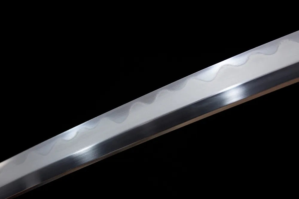 Mid‑section irregular gunome undulating‑pattern hamon steel wakizashi blade surface close‑up shot