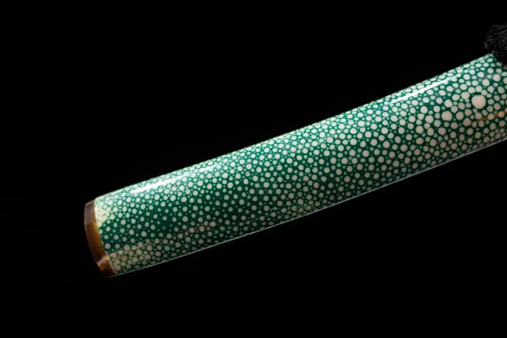 Bottom dark‑green oni‑etched saya green‑aged alloy kojiri end‑cap close‑up
