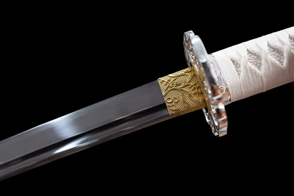 Upper T10 clay‑tempered tachi blade brass habaki blade‑base macro close‑up