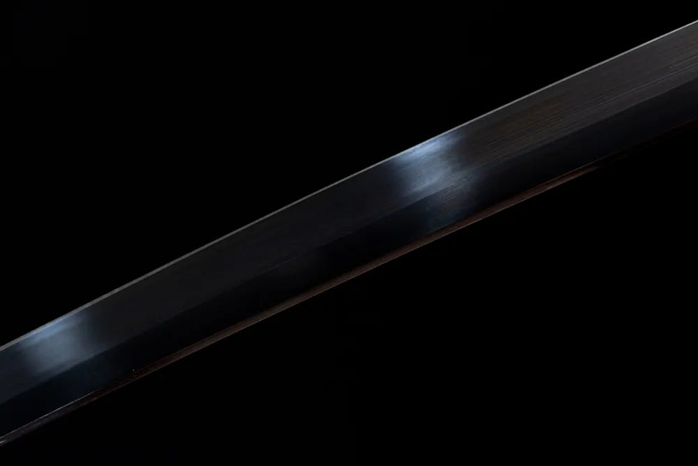 Mid‑section matte blued dark‑steel blade surface texture close‑up shot