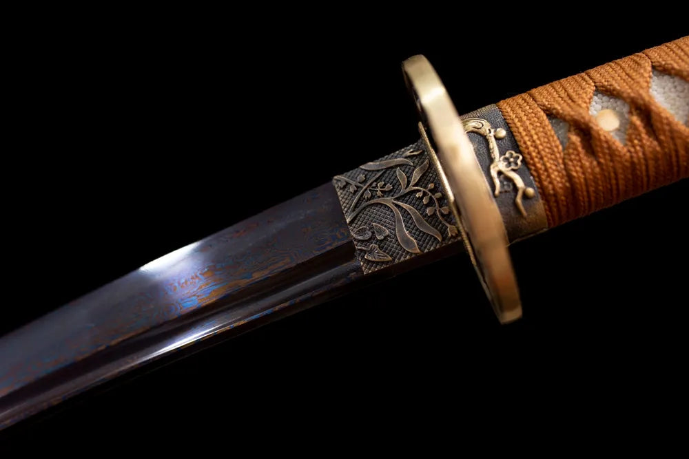 Upper blued‑finish steel wakizashi blade brass habaki dark metal surface macro close‑up