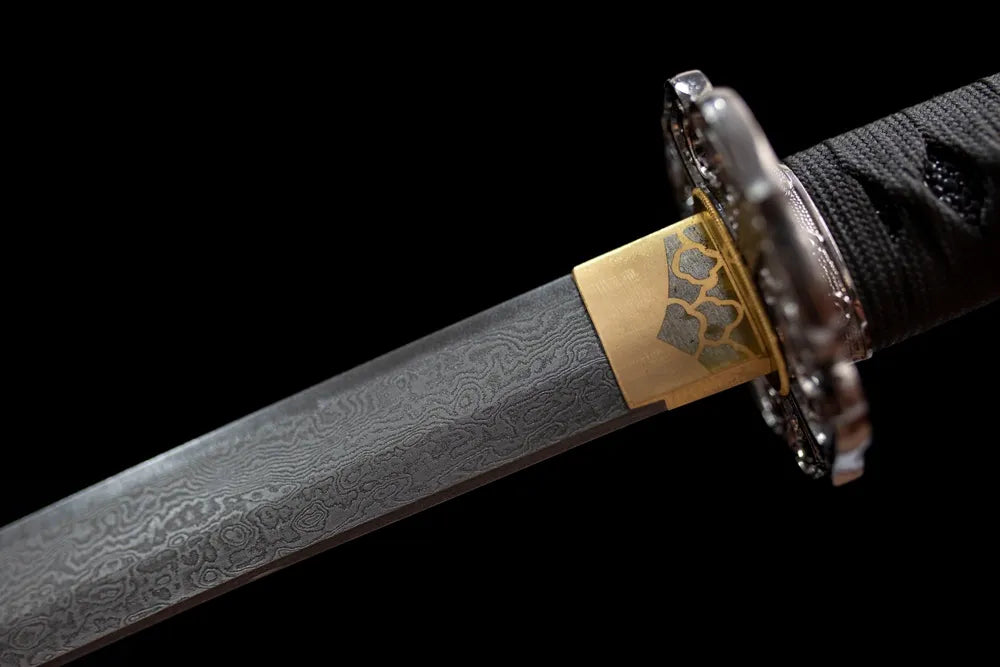 Upper multi‑layer damascus oil‑quenched tachi blade brass habaki layered metal grain macro close‑up