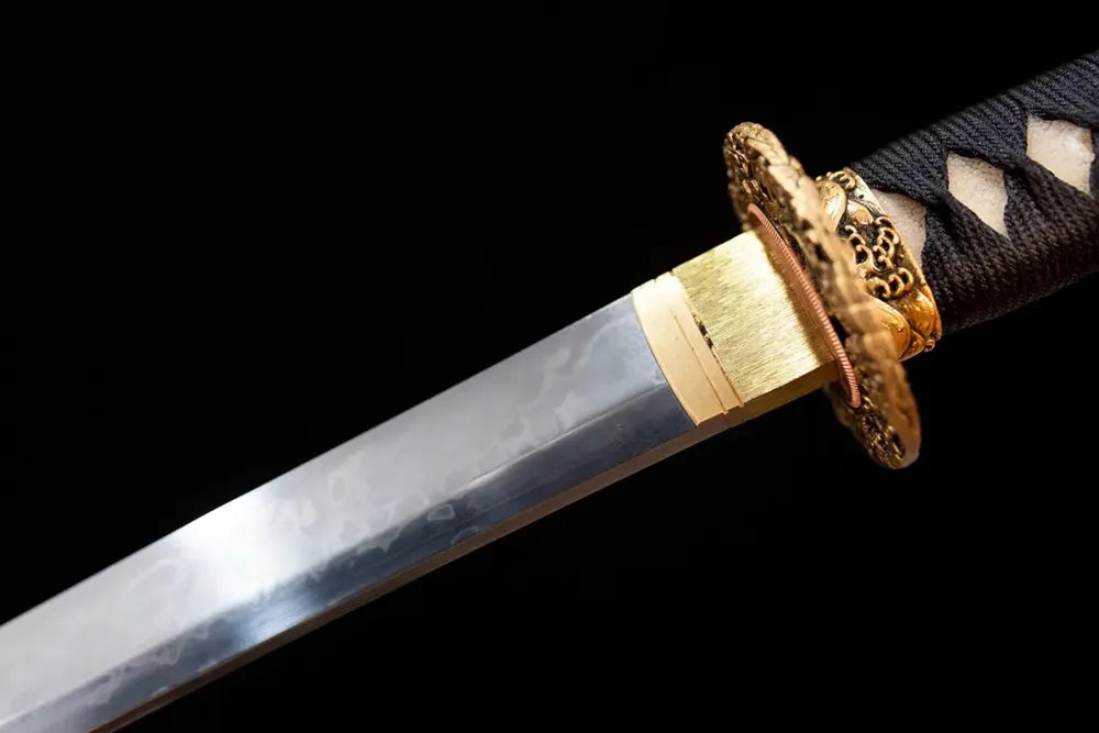 Upper T10 clay‑tempered katana blade brass habaki hitatsura flowing‑water‑undulating hamon temper‑line macro close‑up