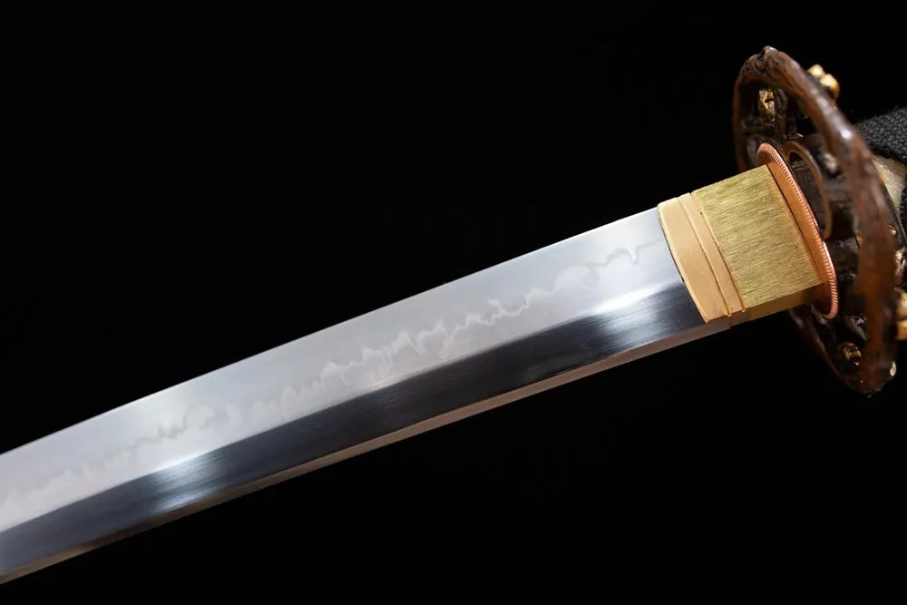 Upper T10 clay‑tempered katana blade brass habaki splash‑pattern cherry‑petal‑scatter undulating hamon temper‑line macro close‑up