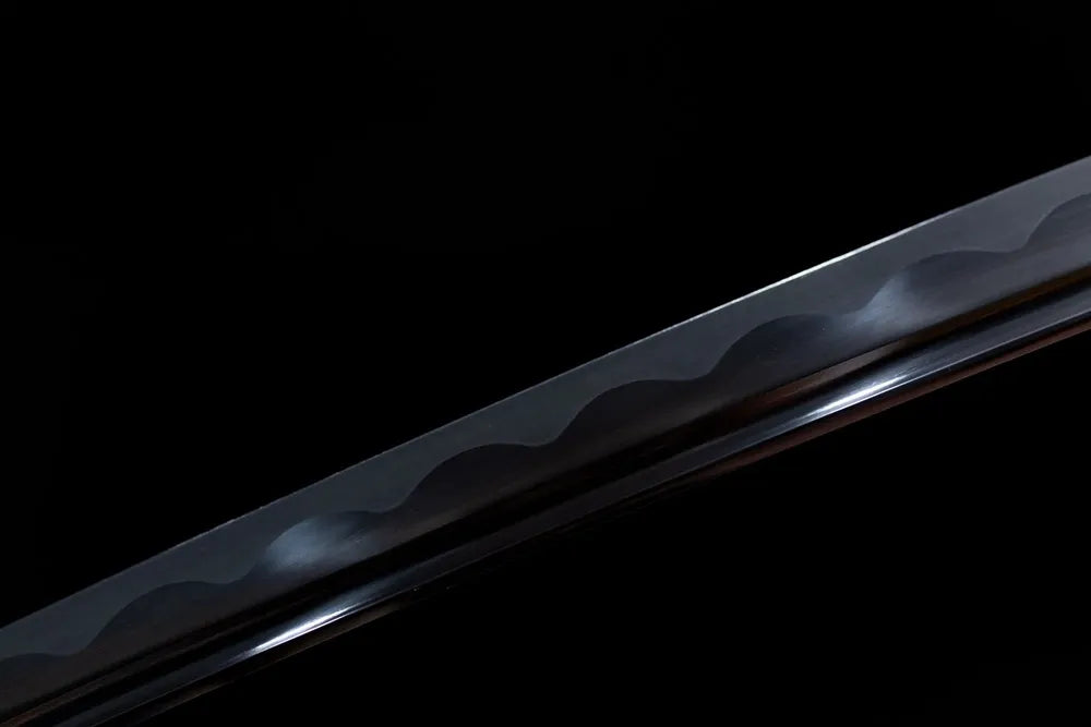 Mid‑blade black coated steel, continuous wave temper grain detail