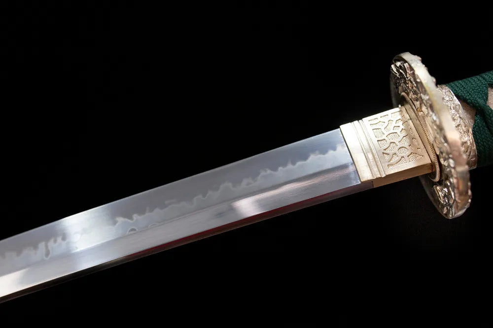 Upper T10 clay‑tempered katana blade brass habaki suguha‑gunome layered‑blossom soft undulating hamon temper‑line macro close‑up