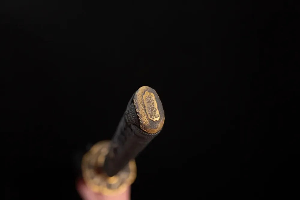 3D‑sculpted prajna‑hannya‑demon‑mask brass‑gilded pommel‑cap detail shot
