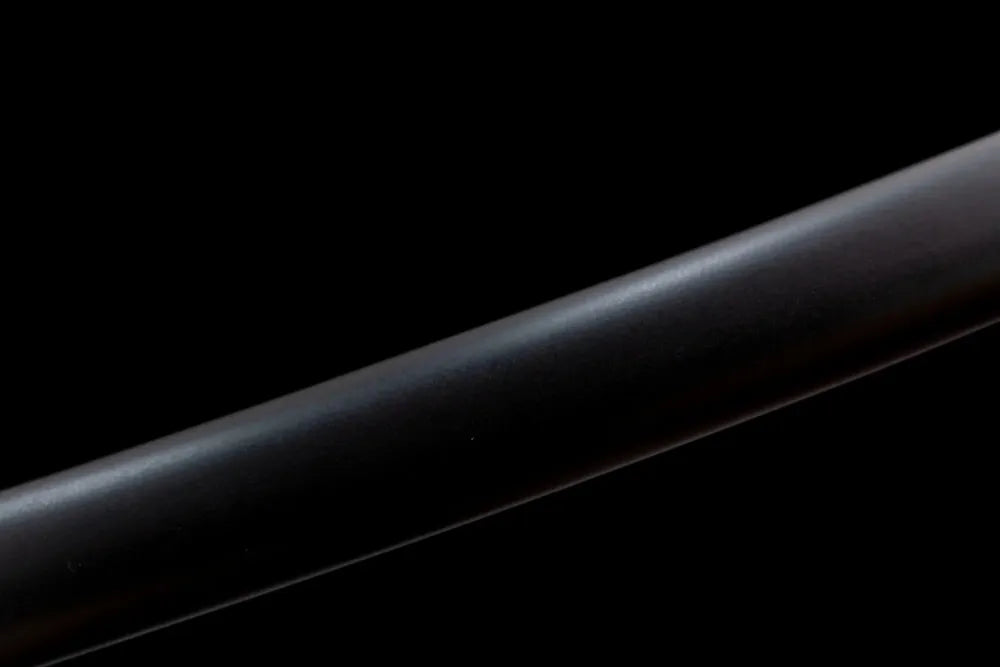 Mid‑section matte‑black solid‑hardwood saya baking‑paint texture close‑up