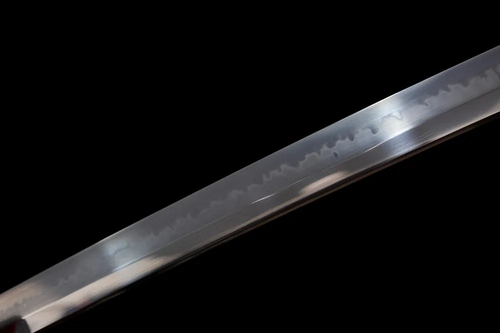 Mid‑section suguha‑gunome layered‑blossom soft‑undulating‑pattern hamon steel katana blade surface close‑up shot