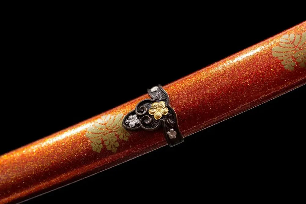 Mid‑section orange glitter‑finish hardwood saya Toyotomi family‑mon emblem print texture close‑up