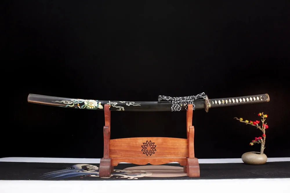 Horizontal laid closed glossy‑black hand‑painted raijin‑fujin thunder‑cloud Raijin‑Katana scabbard flat table‑top front display