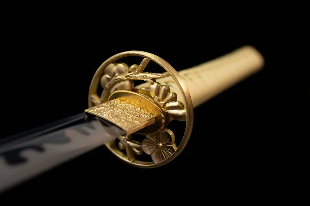 Front open‑work winter‑plum‑blossom‑relief gilded‑alloy katana hand‑guard close‑up