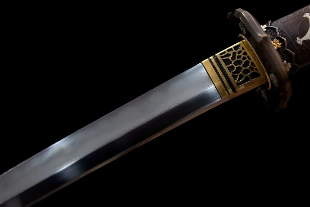 Upper T10 clay‑tempered tachi blade brass habaki natural hamon temper‑line macro close‑up