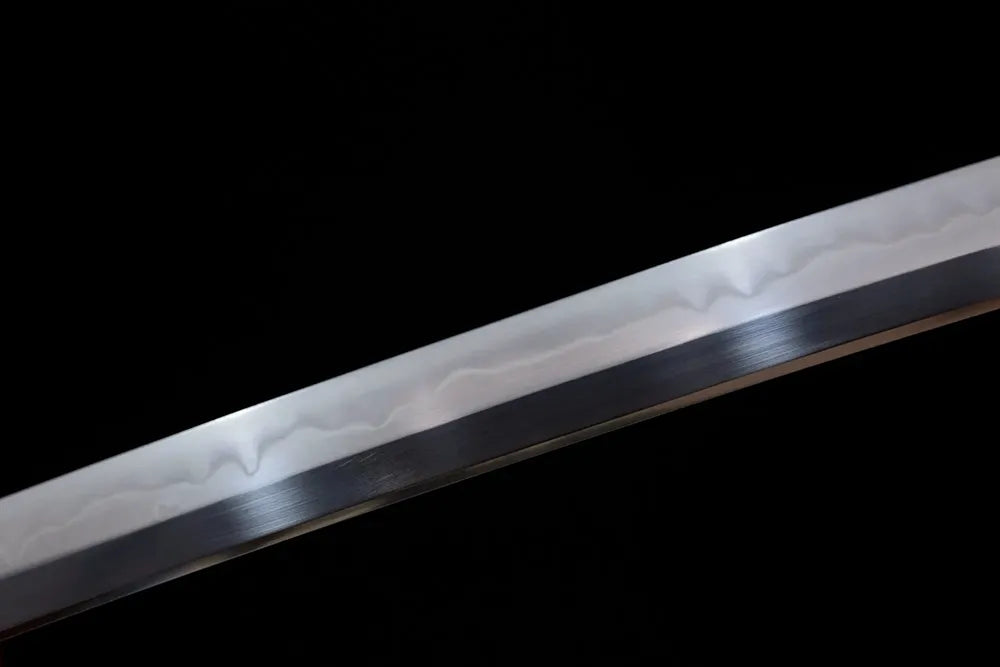 Mid‑section midare‑gunome undulating‑pattern hamon steel katana blade surface close‑up shot