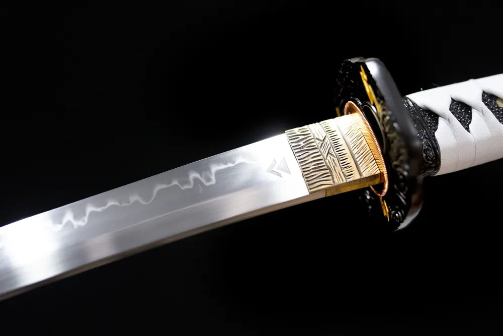Upper T10 clay‑tempered short wakizashi blade brass habaki sanbonsugi three‑peak hamon temper‑line macro close‑up