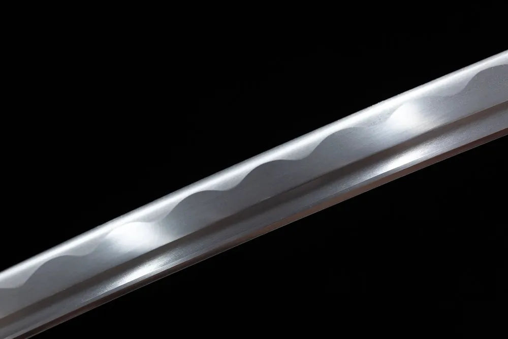 Mid‑section white finished blade surface, wave hamon texture close view